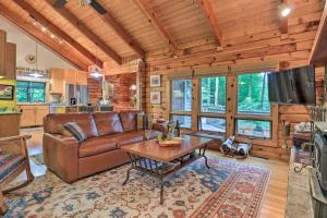 sala de estar con sofá de cuero y mesa en Tree-Lined Cruso Cabin with Game Room and Mtn Views!, en Canton
