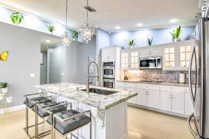 a kitchen with white cabinets and a marble counter top at Sleek Hialeah Home about 20 Mi to Downtown Miami! in Hialeah