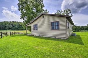 a small house in a grassy field with a fence at McArthur Cabin Peaceful Getaway on Farm! in Stella