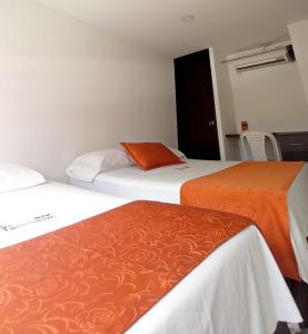 Hotel San Lorenzo في بوكارامانغا: سريرين يجلسون بجانب بعض في غرفة