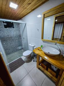 a bathroom with a shower and a sink and a toilet at Pousada Recanto das Araucárias in Urubici