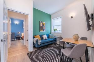 - un salon avec un canapé bleu et une table dans l'établissement 2 Bedroom - Tower Bridge - London City by Prime London Stays M-11, à Londres