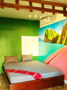 un letto in una stanza con un dipinto sul muro di Lontart Guesthouse a Nggorang
