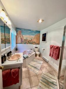 a bathroom with a tub and a sink and a toilet at Seafarers Bed & Breakfast in Tofino