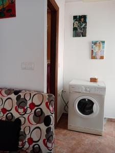 a washing machine in a living room with a couch at Casa Caremy in Almería