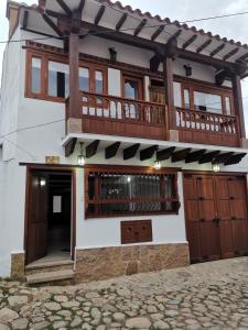 a house with a balcony on top of it at Casa ONCE ONCE in Villa de Leyva