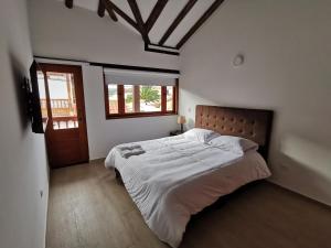 a bedroom with a large bed and a window at Casa ONCE ONCE in Villa de Leyva