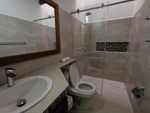 a bathroom with a toilet and a sink and a shower at Casa ONCE ONCE in Villa de Leyva