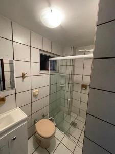 a bathroom with a toilet and a glass shower at Apartamento amplo e completo no centro Balneário Camboriú in Balneário Camboriú