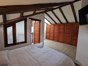 a bedroom with a large white bed with wooden cabinets at Casa ONCE ONCE in Villa de Leyva