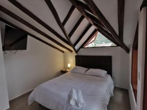 a bedroom with a white bed and a window at Casa ONCE ONCE in Villa de Leyva