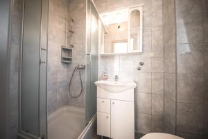 łazienka z umywalką, toaletą i prysznicem w obiekcie Apartments and rooms by the sea Vrsi - Mulo, Zadar - 5848 w mieście Vrsi +32 zdjęcia