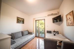 ein Wohnzimmer mit einem Sofa und einem Tisch in der Unterkunft Apartments and rooms by the sea Vrsi - Mulo, Zadar - 5848 in Vrsi