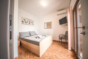 a small bedroom with a bed in a room at Apartments and rooms by the sea Vrsi - Mulo, Zadar - 5848 in Vrsi