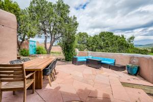 een patio met een houten tafel en blauwe banken bij Home on the Range in Santa Fe