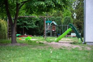 a playground with a green slide in a park at NIENOVO - Apartament Kórnik niedaleko jeziora i widok na Arboretum in Kórnik