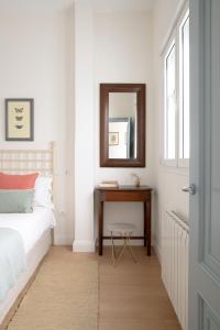 a bedroom with a bed and a table with a mirror at Plaza Nueva 2 Bedrooms & 2 Bathrooms in Seville