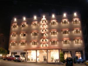 a large white building with lights on it at night at Petra Sella Hotel in Wadi Musa