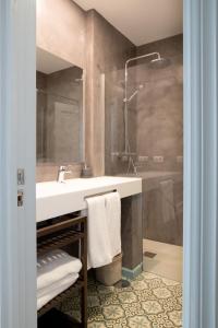 a bathroom with a sink and a shower at Plaza Nueva 2 Bedrooms & 2 Bathrooms in Seville