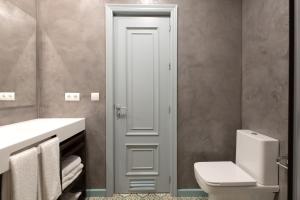a white bathroom with a toilet and a sink at Plaza Nueva 2 Bedrooms & 2 Bathrooms in Seville
