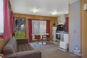 a living room with a couch and a table at Lake Fyans Holiday Park in Lake Fyans
