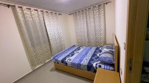 a small bedroom with a bed and a curtain at Saidia caracas in Saïdia