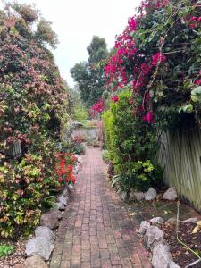 a brick path in a garden with flowers at Hill Haven in Brisbane