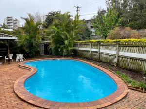a swimming pool in a brick yard with a fence at Hill Haven in Brisbane