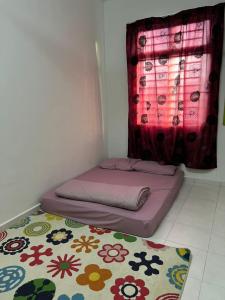 Ce lit se trouve dans un dortoir doté d'une fenêtre et d'un tapis. dans l'établissement Qmar Melaka Homestay, à Kampong Kerubong