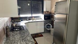 a kitchen with a stainless steel refrigerator and a dishwasher at Saidia Caracas AS in Saïdia