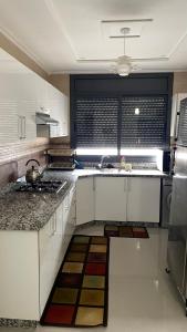 a kitchen with white cabinets and a sink and a window at Saidia Caracas AS in Saïdia