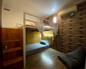 sypialnia z łóżkiem piętrowym i ceglaną ścianą w obiekcie Dong Paloh Hostel w mieście Munduk