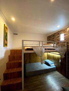 Pokój z 2 łóżkami piętrowymi i schodami w obiekcie Dong Paloh Hostel w mieście Munduk