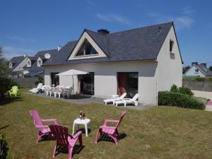 ein Haus mit rosa Stühlen und Tischen auf einem Hof in der Unterkunft Holiday home close to the beach, Plounéour-Brignogan-Plages in Plounéour-Trez