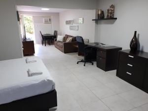 een slaapkamer met een bed, een bureau en een bank bij Studio 4 - ground floor Fremantle apartment in Fremantle