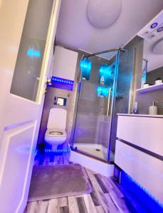 a bathroom with a toilet and a shower with blue lights at Studio DeLux in Giurgiu