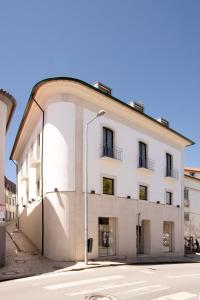 un edificio blanco con una luz de la calle delante de él en RIACENTRUM - Smart Residence, en Aveiro