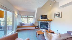 sala de estar con sofá y chimenea en Cozy 1BR, steps from Creekside Gondola by Harmony Whistler Vacations en Whistler