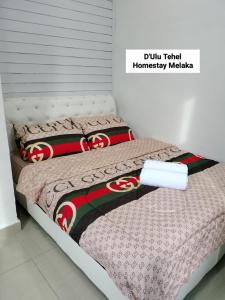 a bedroom with a bed with a comforter on it at D'Ulu Tehel Homestay Melaka - Private Swimming Pool in Melaka +22 photos