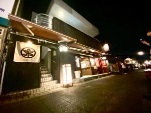 um edifício com uma placa ao lado à noite em 外宮前別邸　星凪庵 em Ise