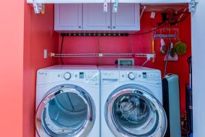 a washer and dryer in a red laundry room at The H-House in Waikoloa