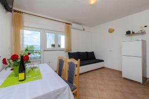 a dining room with a table and a couch at Apartments Jurica in Drače