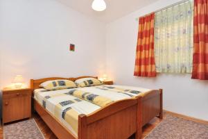 1 dormitorio con cama y ventana en Apartment Seget Donji 10023a, en Trogir