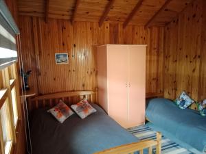 a bedroom with two beds in a wooden cabin at Bungalow with access to a large garden near beach in Kemer