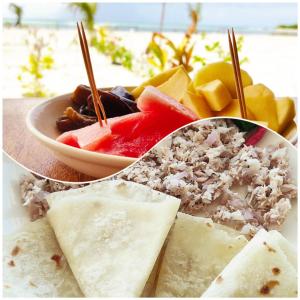 a plate of food with fruit and a bowl of dip at La Isla Tropica in Guraidhoo
