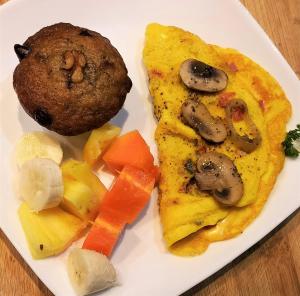 a plate of food with omelet and mushrooms and vegetables at Casa Blanca Inn in Torio