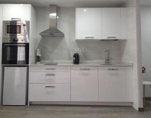 a white kitchen with white cabinets and a sink at Apartamento Comarca de Haro in Haro