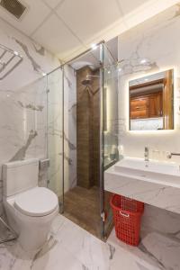 a bathroom with a toilet and a shower and a sink at Woody House Boutique in Ho Chi Minh City