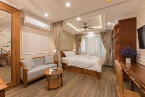 1 dormitorio con cama, sofá y mesa en Woody House Boutique en Ho Chi Minh