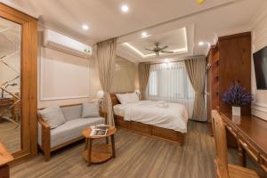 a bedroom with a bed and a couch and a table at Woody House Boutique in Ho Chi Minh City